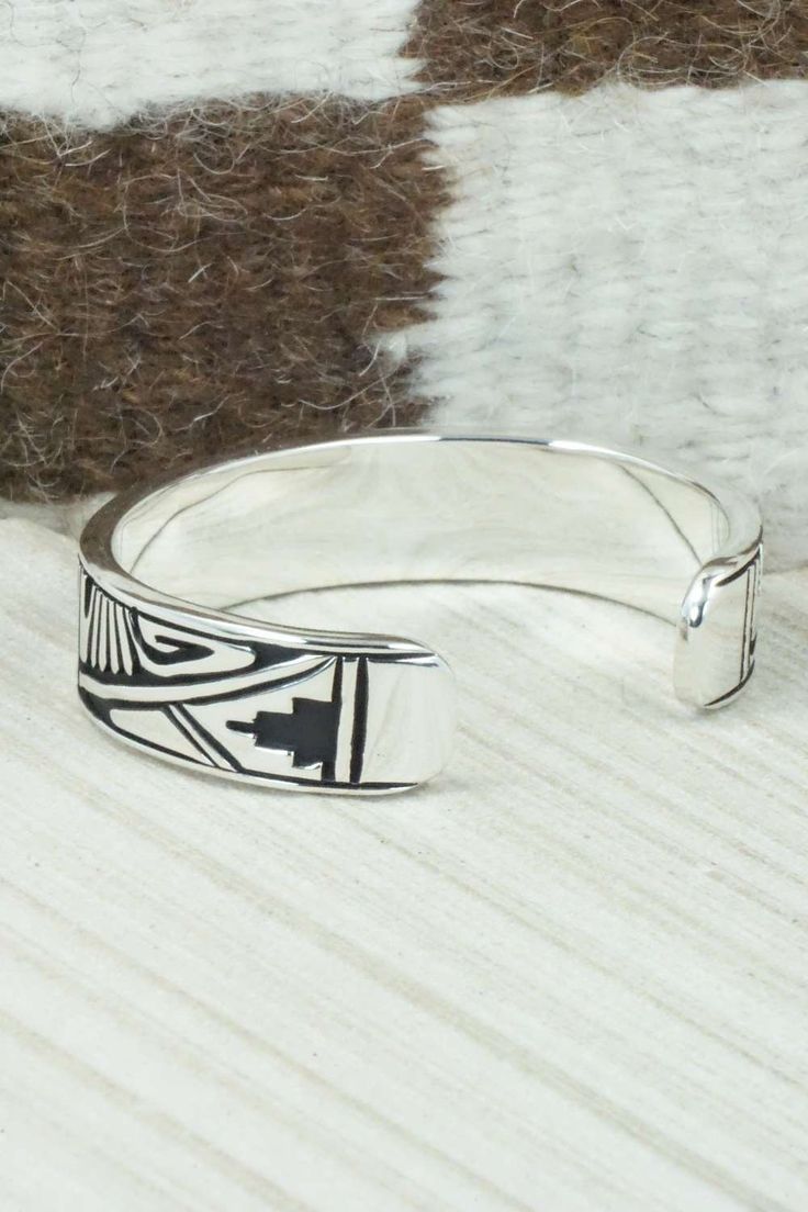 This sterling silver and bracelet was made by Navajo silversmith Kerry Begay. The inside is signed KB and stamped sterling.Size: 5" (will fit up to a 6" wrist)Gap: 1"Width: 1/2"Free shipping on all orders! We ship with USPS and always include tracking. All orders ship within a day of payment.Returns are accepted up to 30 days after you receive your order. Just send us a message. Our shop offers cash back or store credit. The item must be returned in new condition. Adjustable Artisan Sterling Silver Bracelet, Artisan Sterling Silver Bracelet With Oxidized Finish, Etched Sterling Silver Bangle, Sterling Silver Etched Bangle Bracelet, Etched Sterling Silver Bangle Bracelet, Etched Sterling Silver Bracelet In Traditional Style, Southwestern Sterling Silver Polished Bangle Bracelet, Southwestern Sterling Silver Bangle With Polished Finish, Traditional Etched Sterling Silver Bracelet