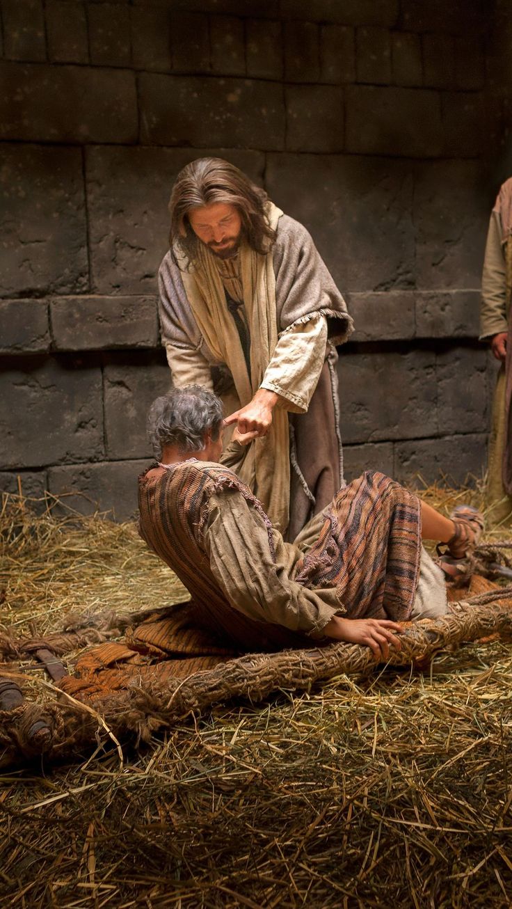 a man kneeling down next to a woman on the ground