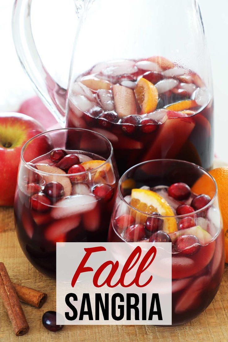 two glasses filled with sangria next to oranges and cinnamon sticks