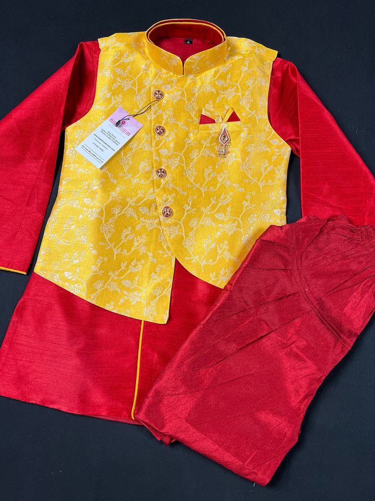 Boys Kurta Pajama Set with Jacket in Floral Weave Work. Yellow color Jacket with Floral Weaving Work with matching Kurta Brooch and buttons. The bottom is a matching color Balloon style. The Combination of Red, Maroon and Yellow makes the Kurta wearable for all the occasion. Item : Boys Kurta Pajama Ready to Wear : Yes Kurta Color : Yellow and Red Pajama Color : Maroon (Balloon Style) Fabric : Silk Pocket : Yes Lining : Yes Disclaimer - There can be little variation in the color due to screen re Festive Art Silk Sets With Cutdana Details, Festive Art Silk Sets With Cutdana, Designer Long Sleeve Sets For Diwali, Transitional Art Silk Sets With Zari Work, Festive Sets With Zari Work On Straight Kurta, Festive Designer Sets With Front Open Design, Festive Designer Sets With Front Open, Sets With Traditional Drape For Navratri Puja, Festive Transitional Chanderi Sets