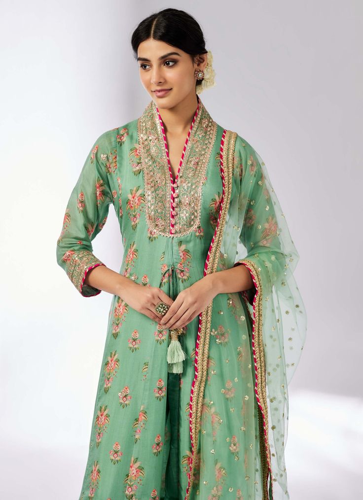 Elevate your style with this delicately embroidered ensemble that adds shimmer and richness. The long-sleeved, front-open kurta in luxurious cotton silk pairs beautifully with linen satin palazzo pants and a sheer net dupatta. Easy to carry and perfect for any occasion, this set effortlessly blends elegance with versatility. Eid Slub Silk Palazzo Set With Sheer Dupatta, Chanderi Palazzo Set With Resham Embroidery And Long Sleeves, Green Anarkali Cotton Silk Palazzo Set, Green Cotton Silk Sharara For Festive Occasions, Festive Green Cotton Silk Sharara, Long Sleeve Cotton Silk Kurta With Sheer Dupatta, Festive Cotton Silk Pant Set With Chikankari Embroidery, Pista Green Cotton Silk Palazzo Set With Straight Kurta, Pista Green Slub Silk Sets With Dupatta