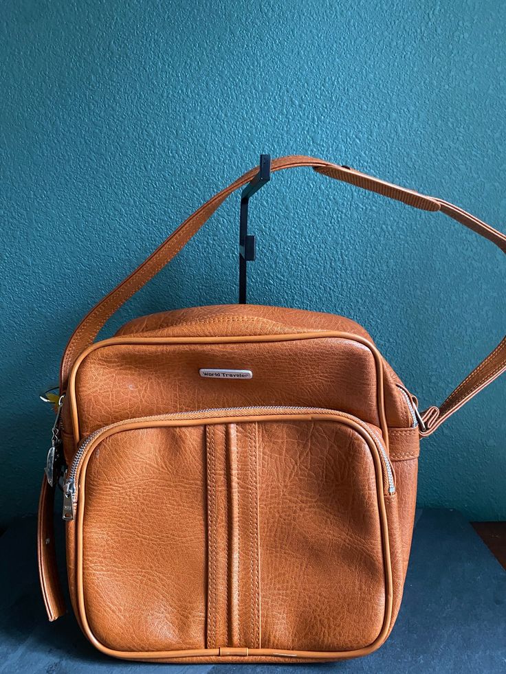 Vintage Brown World Traveler Bag with side lock and two keys attached  -shoulder strap  - 2 large zipper pockets  - In very good condition Vintage Satchel With Detachable Strap For On-the-go, Classic Travel Pouch Satchel, Retro Everyday Shoulder Bag With Zipper Closure, Retro Bags With Zipper Closure For On-the-go, Vintage Satchel Shoulder Bag With Zipper Closure, Retro Rectangular Shoulder Bag With Zipper Pocket, Retro Shoulder Bag With Zipper Pocket, Vintage Everyday Shoulder Bag With Zipper Closure, Everyday Vintage Shoulder Bag With Zipper Closure