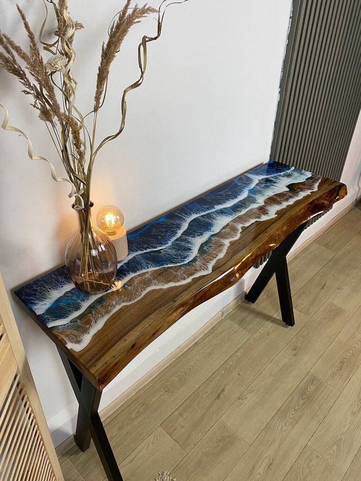 a wooden bench sitting on top of a hard wood floor next to a vase filled with flowers