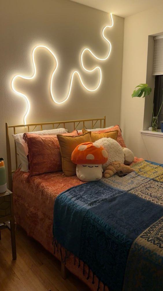 a bed room with a neatly made bed and a neon sign above the headboard