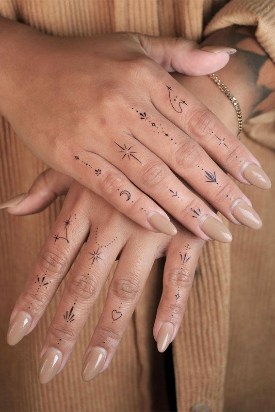 two hands with tattoos on them, one has an arrow and the other has stars