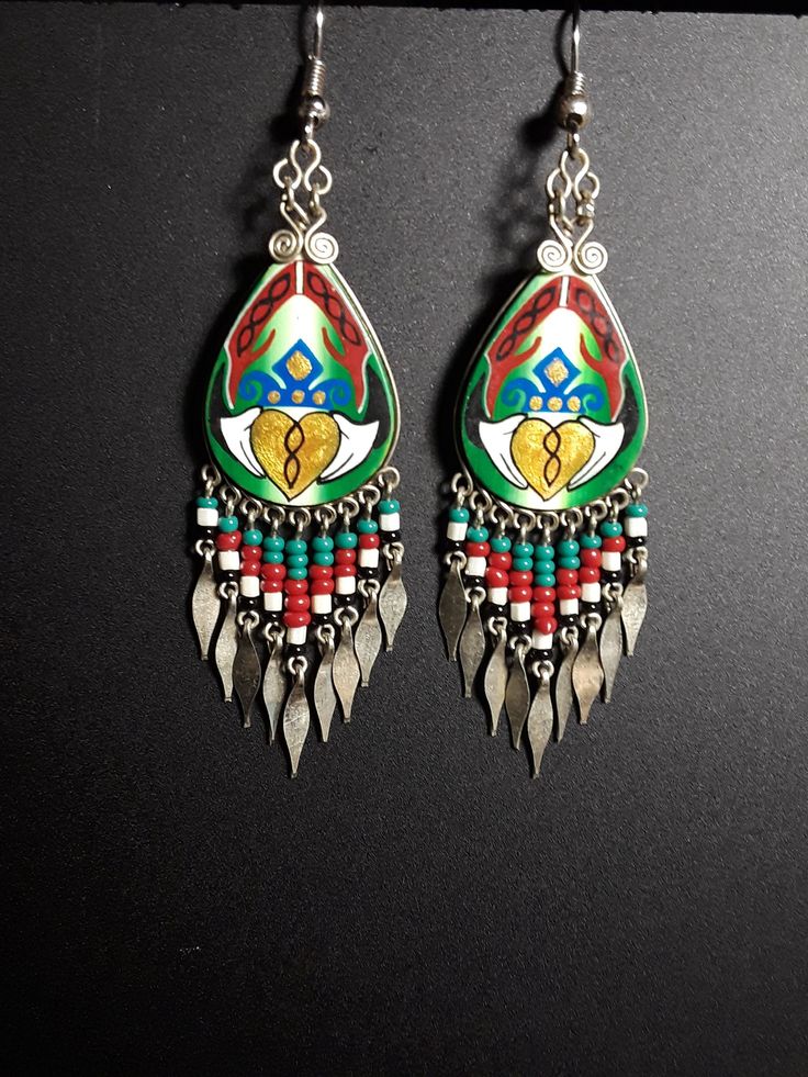 Hand painted center bead with a Celtic style claddagh with seed bead tassels.  Tassel beads are green, red, white, and black. Ear wires are surgical steel. Traditional Green Teardrop Beaded Earrings, Traditional Green Beaded Dangle Earrings, Traditional Red Jewelry With Tassels, Traditional Multicolor Beaded Earrings Nickel Free, Traditional Multicolor Tassel Jewelry, Traditional Hand Painted Dangle Jewelry, Traditional Hand Painted Green Jewelry, Traditional Hand-painted Green Jewelry, Traditional Green Hand Painted Jewelry