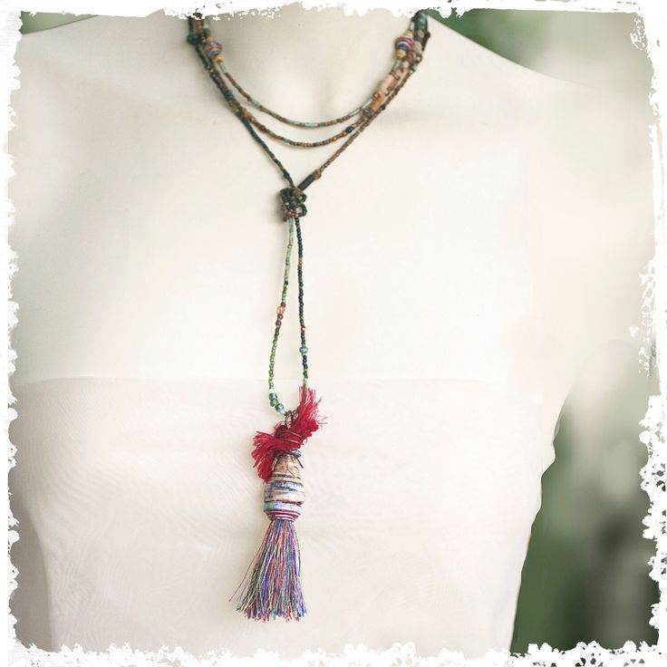 This versatile necklace can be worn with or without the stunning tassel pendant. Keep it long or wrap it around the neck or remove the pendant and wrap it around the wrist. The unusual pendant is made from my hand-rolled paper beads capped with a patinaed green Greek bead and wire-wrapped sari silk on top of that. It's a tribal-vibe look that complements the eclectic mix of beads in the long necklace. I made a silver swirled clasp to finish the look. The pendant slides off easily so that the necklace can also be worn as a wrap bracelet. ←→ LENGTH: 34" long, Tassel pendant adds about 4"   ❦ All my jewelry comes in a cute linen pouch or a pretty pillow box. If some of your items are gifts let me know and I will wrap them separately. ✦I am so glad you visited RocksandPaperSwans ... And thanks Handmade Lariat Tassel Necklace, Bohemian Lariat Necklace With Tassels, Elegant Adjustable Hand Wrapped Necklaces, Bohemian Hand Wrapped Necklaces For Layering, Bohemian Long Necklace With Tassels, Adjustable Bohemian Long Necklace With Tassels, Adjustable Handmade Long Necklace For Layering, Handmade Artisan Lariat Long Necklace, Artisan Handmade Lariat Long Necklace