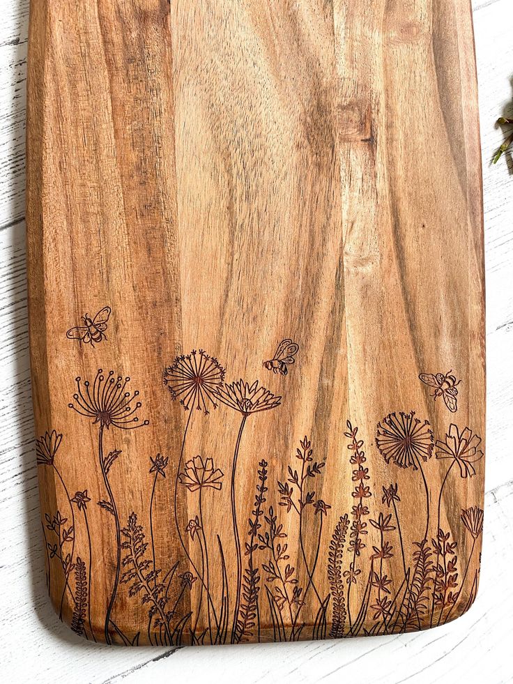 a wooden cutting board with flowers on it