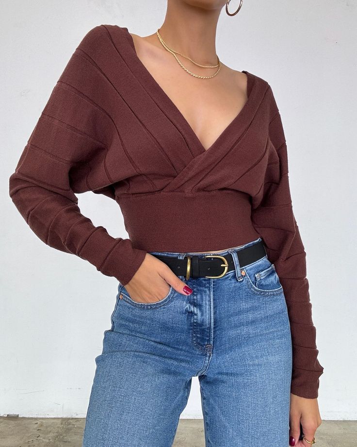 This lightweight brown-toned sweater features a deep v-neckline, long puff sleeves, and a fitted waist. Wear it on or off the shoulders with a bralette and gold jewelry for the perfect look. More Details - Looser fit at the top with a fitted waist - Does stretch - True to size - Cropped hem - Color may vary due to the lighting - Model is wearing a size small Model Details Height 5'7 | Chest 34" Waist 27" Hips 36.5" | Weight 118lbs | Wears a US size small in tops and dresses. SIZE GUIDE SMALL MED