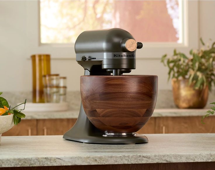 an image of a kitchen scene with focus on the mixer and fruit in the bowl