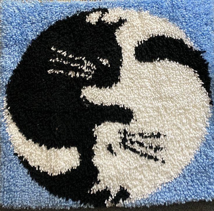 a blue rug with a black and white cat on it's face in the center