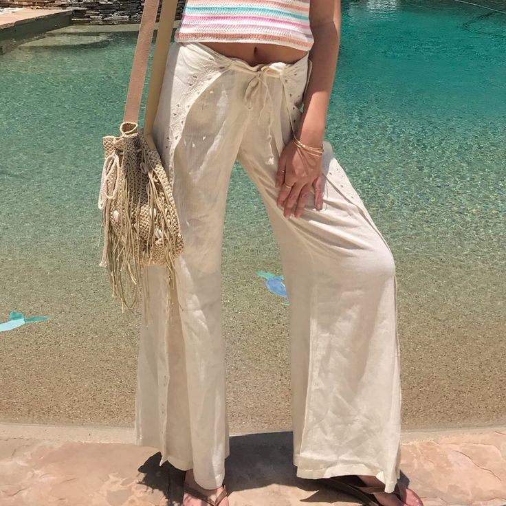 These Gorgeous Beach Pants Feature A Wrap Around Style With A Front Tie, So You Get A Perfect Fit. Elastic Back. Comfortable Gauze Fabric, With Touches Of Embroidery And Cut Out Detail. Of Embroidery And Cut Out Detail. 100% Cotton. Semi Sheer. 32” Inseam. Machine Wash. Available In Small(1-3) And Medium( 5-7). Laying Flat, Small Measures 13” Across Waist. Fits Waist 25”-26”, And Hips 35”-36”. Medium Measures 14” Across Waist. Fits Waist 27”-28”, Hips 37”-38”. Relaxed Cotton Pants For Vacation, Casual Beach Bottoms For Spring, Relaxed Cotton Beach Bottoms, Chic Bottoms For Day Out During Resort Season, Casual Beach Vacation Bottoms, Casual Bottoms For Summer Beach Outings, Casual Summer Beach Bottoms, Vacation Straight Cotton Pants, Cotton Straight Pants For Vacation