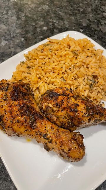 two pieces of chicken and rice on a white plate