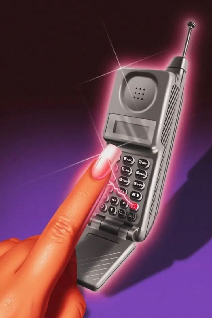 an old cell phone being pointed at by someone's finger on a purple background