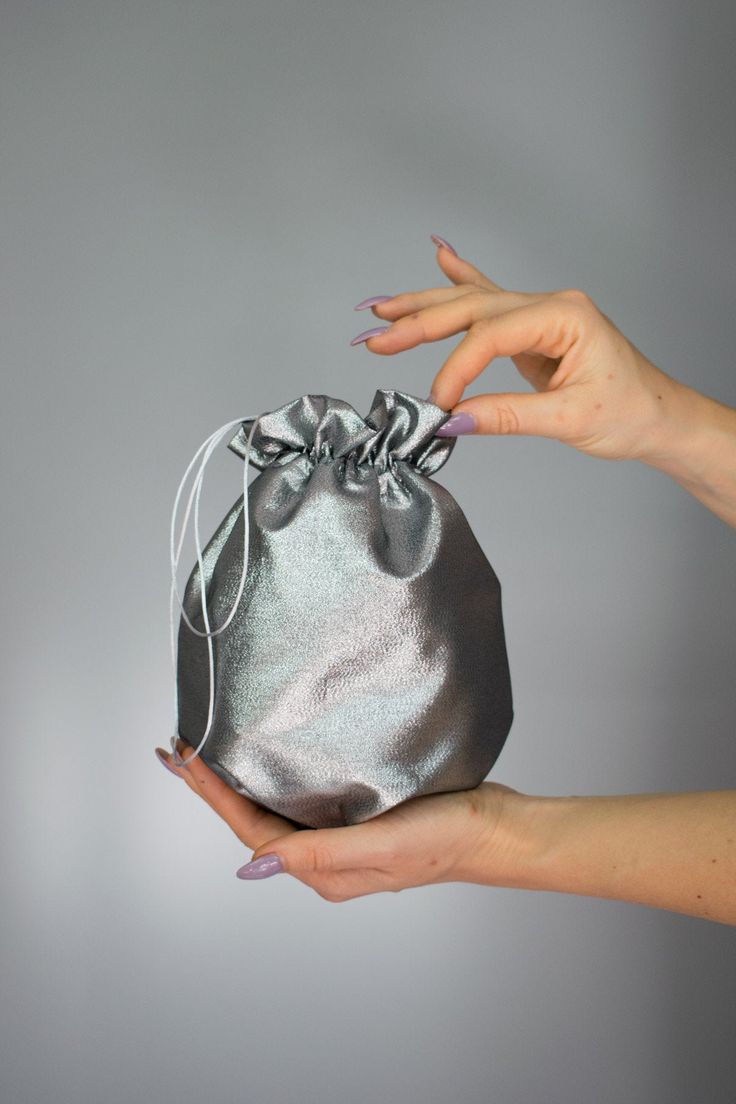 Elegant satin bag / money bag / purse ! Ideal for your wedding day, night out, party ,special occasion Made of beautiful silver grey bridal taffeta fabric. You can change colors Fabric : taffeta Lining : poliester Size : approx. 18 cm x 18 cm Silver Evening Bag With Dust Bag For Party, Silver Pouch Bag For Gift, Silver Pouch Evening Bag As Gift, Elegant Metallic Bag For Gift, Elegant Metallic Bag As Gift, Elegant Metallic Bags For Gifts, Elegant Gray Bag For Gift, Gray Pouch Bag For Gift, Gray Pouch Bag As Gift