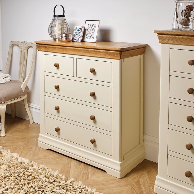 a white dresser sitting next to a chair in a room