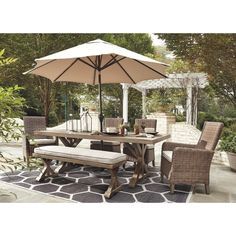 an outdoor dining table with umbrella and chairs