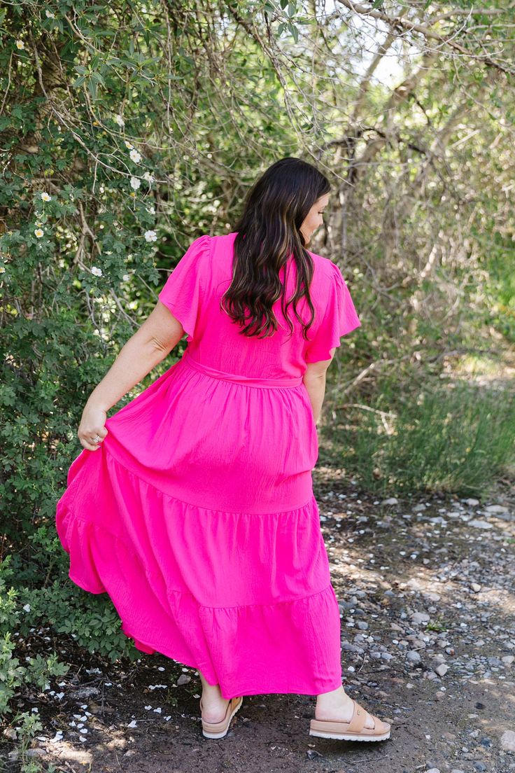 Get ready to turn heads in the Raelynn Maxi dress! This hot pink stunner features a flattering v-neck, tiered design, and short flutter sleeves. Plus, it comes with convenient pockets and a belt to cinch your waist and add some extra flair! Talk about versatile and stylish (and super comfy, too)! Fits true to size. Model is wearing a 1X and is 5'6". Size Chart Length Bust Waist 1x 56" 44" 36" 2x 58" 47" 40" 3x 58" 50" 43" *Measurements are approximate and are measured while hanging* Fabric and C Pink Flowy Tiered Dress With Short Sleeves, Pink V-neck Tiered Dress For Spring, Tiered Dresses, Teen Dress, Hanging Fabric, Spring Fits, Pink Maxi, White Outfits, Flutter Sleeves