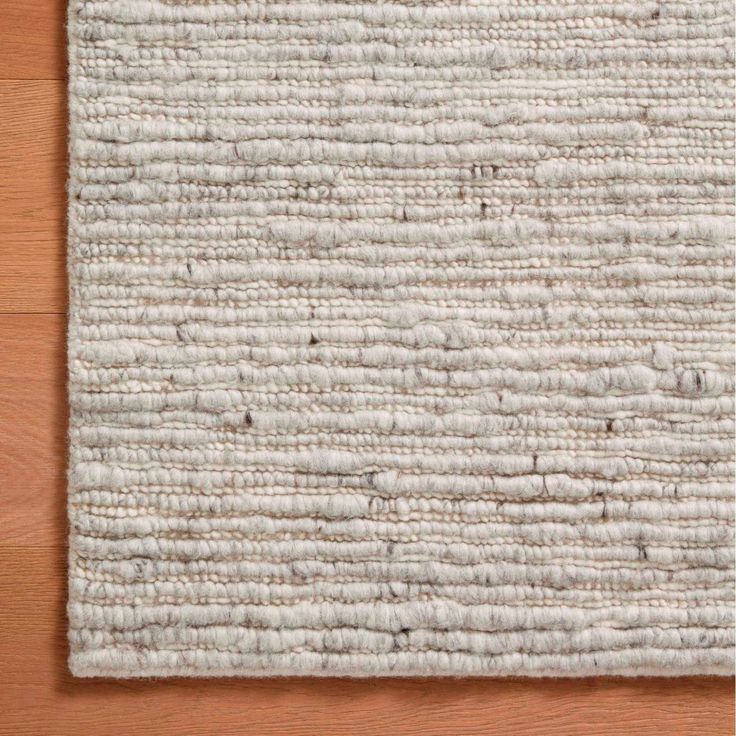 a white rug on top of a wooden floor