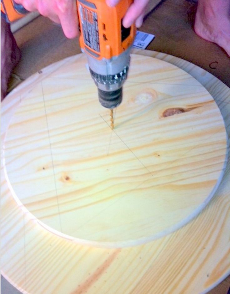 a person using a drill to attach the wood on top of a round table with holes in it