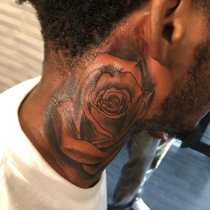 a man with a neck tattoo that has a rose on the side of his head