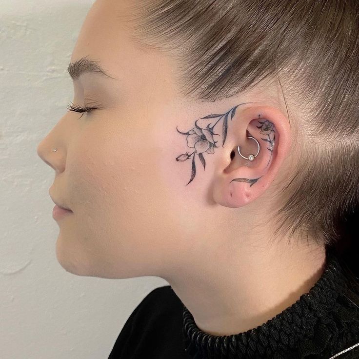 a woman with a flower tattoo on her left ear