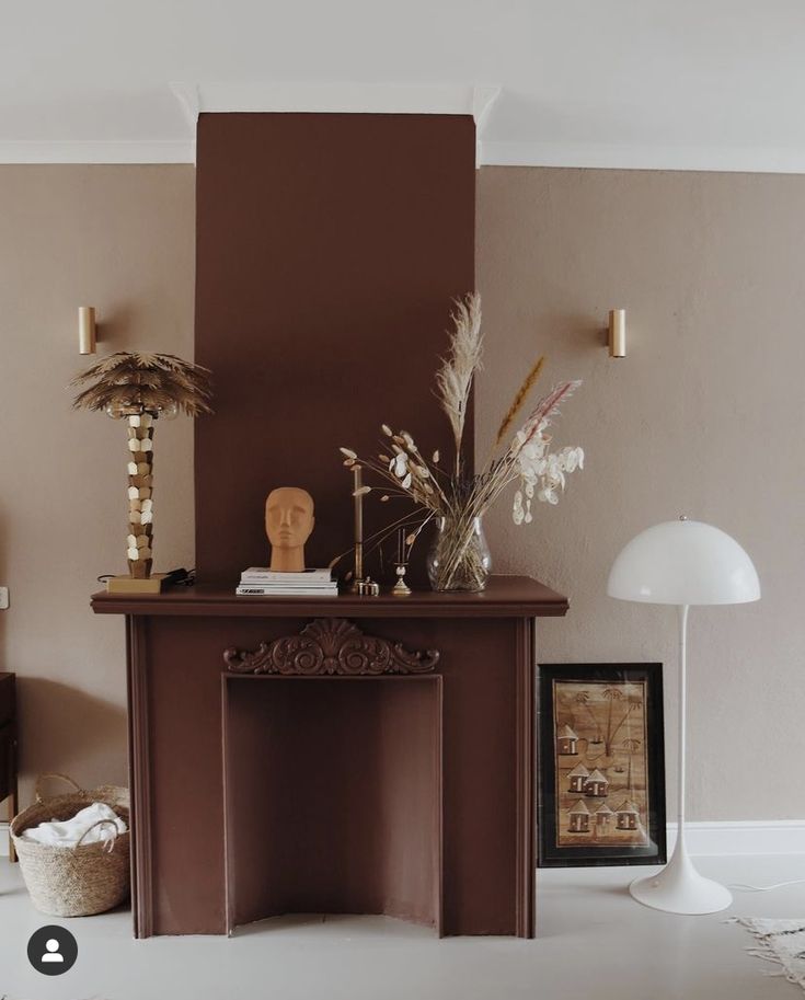 a living room with a fire place next to a lamp and pictures on the wall