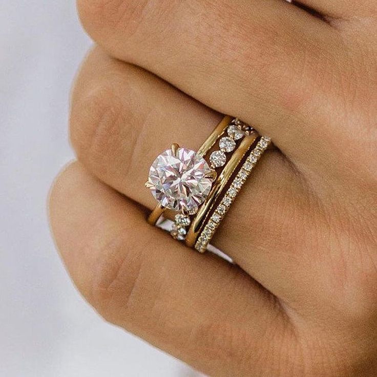 a woman's hand with two rings on it and a diamond in the middle