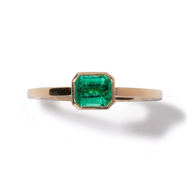 === The Classic Emerald ring is a timeless addition to your collection of jewelry. Featuring a stunning Emerald with a polished and brushed band. A goldfish is engraved on one side of the band to represent abundance and prosperity. Stone: Emerald (0.63 ct) Material: Recycled 18kt yellow gold Made in: Japan Resizable: yes Unsure of your size? Find your size at home Personalization: Custom Engraving Available === Say “I love you” with Milamore. A collection for gemstone lovers, featuring sapphires Emerald Ring With Single Diamond For Anniversary, Classic Emerald Ring For Promise, Timeless Emerald Ring With Polished Finish, Timeless Yellow Gold Emerald Ring, Timeless Yellow Gold Emerald Signet Ring, Timeless Yellow Gold Signet Ring With Emerald, Yellow Gold Emerald Ring With Tension Setting As Gift, Timeless Polished Emerald Ring, 14k Yellow Gold Emerald Ring With Tension Setting