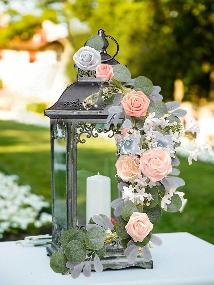 a lantern with flowers and greenery on it