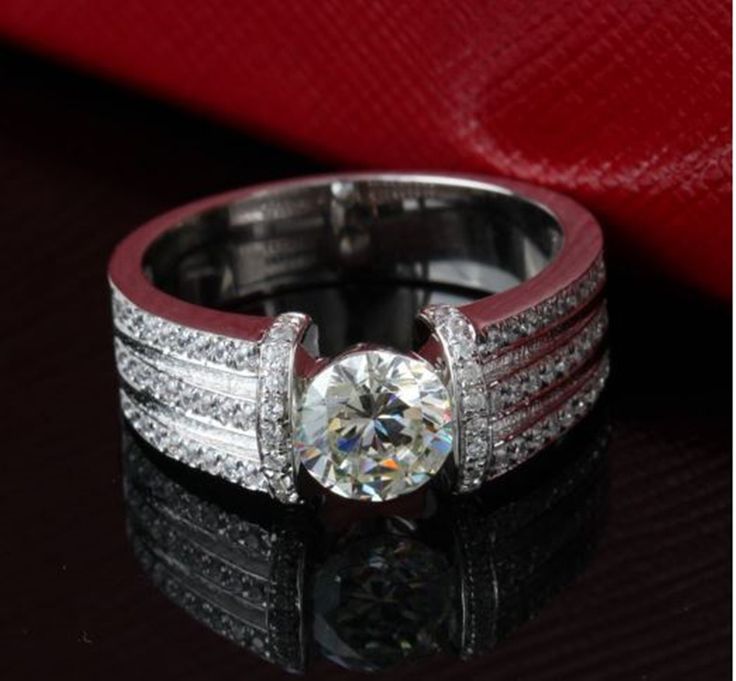 a diamond ring with two rows of diamonds on it and a red cloth in the background