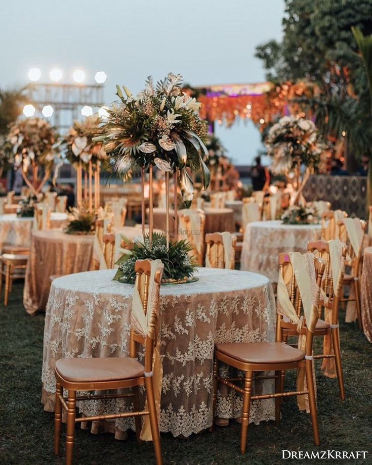 an outdoor event with tables and chairs set up for a formal function at night time