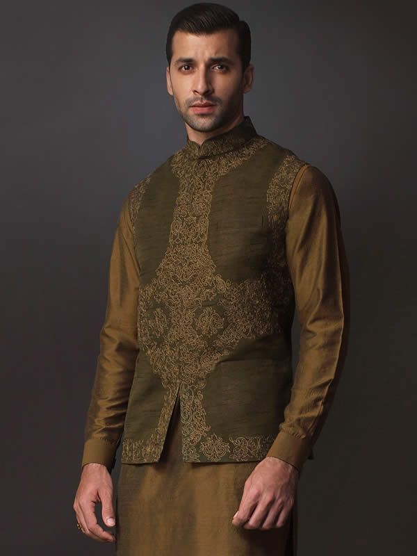 WaistcoatColor: Olive DrabFabric: Raw SilkSmart looking designer waistcoat features delicate embroidery accent the front and collarHidden front hooks closureInner:Complement with dark brown kurta and pajama.Additional Accessories:Peshawari Sandal / Khussa: US$30 Designer Sleeveless Embroidered Nehru Jacket, Sleeveless Embroidered Nehru Jacket For Designer Wear, Elegant Sleeveless Kurta For Transitional Season, Sleeveless Embroidered Bandhgala For Festive Season, Festive Sleeveless Embroidered Bandhgala, Festive Embroidered Sleeveless Bandhgala, Sleeveless Embroidered Nehru Jacket For Eid, Traditional Nehru Jacket For Semi-formal Transitional Season, Fitted Sleeveless Nehru Jacket With Intricate Embroidery