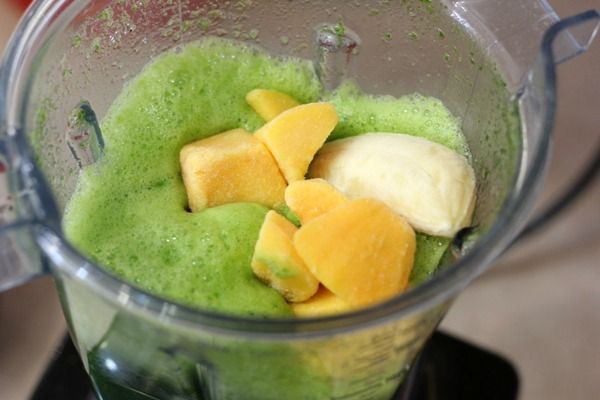 a blender filled with green and yellow fruit