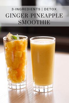 two glasses filled with orange and pineapple smoothie next to each other on a table