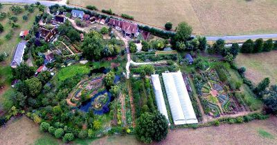 an aerial view of a farm with lots of trees and plants in the middle of it