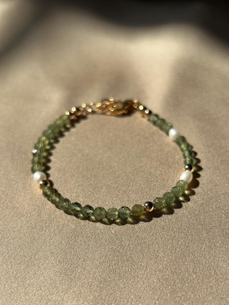 This dainty, bright green bracelet is perfect for adding a touch of green to your jewelry collection. The intricate design showcases a mix of delicate beads and vibrant gemstones. Photos are taken under different lighting conditions, which may cause slight variations in the bracelet's color to appear. These dainty beads are 4mm. The adjustable clasp and extension ensures a perfect fit for any wrist size, making it a versatile addition to any jewelry collection. Made with green apatite, and fresh water pearl.  JEWELRY CARE ♥︎Remove before bathing, swimming, exercising, and going to bed ♥︎Apply lotions and perfumes before jewelry ♥︎Store in a cool, dry place ♥︎Wipe clean with a lint free cloth **Orders are processed within 1-3 business days and then shipped via USPS. Shipping can take up to Green Pearl Bracelet, Green Dainty Jewelry For Everyday, Dainty Green Jewelry For Everyday, Dainty Green Everyday Jewelry, Elegant Rondelle Beaded Bracelets With Colorful Beads, Elegant Rondelle Beaded Bracelets, Green Rondelle Jewelry With Natural Stones, Green Beaded Bracelet With Tiny Beads As Gift, Green Rondelle Natural Stone Jewelry