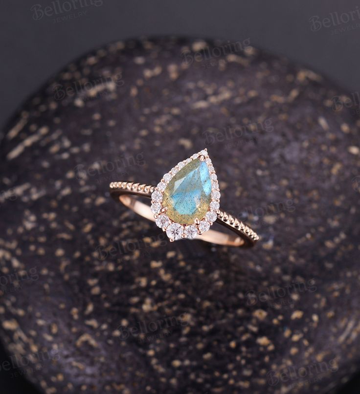 Vintage Labradorite engagement ring Pear shaped Rose gold ring milgrain art deco moissanite ring unique art deco ring anniversary ring Back to Belloring shop: https://www.etsy.com/shop/BrilliantRing?ref=l2-shopheader-name ---------------------------Specifications---------------------- Engagement ring Center Stone - 6*9mm pear cut Labradorite Side stones - 0.323ct Moissanite or Diamond ---------------------------DIMENSIONS----------------------- The Width of the Band - 1.4mm The Thickness of the Teardrop Bezel Setting Promise Ring, Teardrop Bezel Setting Jewelry For Promise Ring, Unique Anniversary Jewelry With Halo Setting, Unique Jewelry With Halo Setting For Anniversary, Pear-shaped 14k Gold Gemstone Wedding Ring, Pear-shaped Moissanite Jewelry With Prong Setting, Delicate Pear-shaped Diamond Accent Jewelry, Unique Pear-shaped Wedding Jewelry, Delicate Pear-shaped Jewelry With Diamond Accents