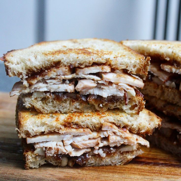 a cut in half sandwich sitting on top of a wooden cutting board