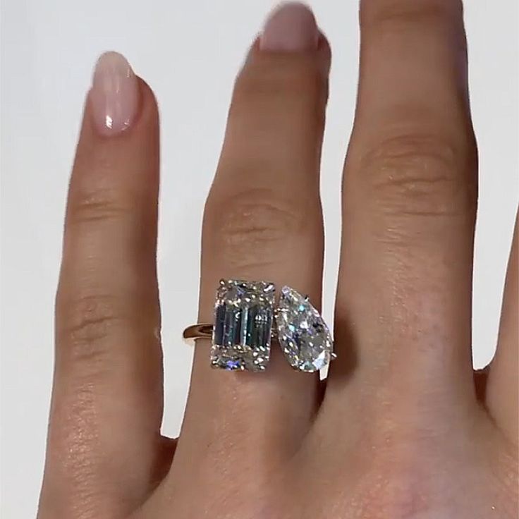 a woman's hand with a ring on it and an emerald stone in the middle