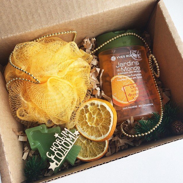 an open box containing oranges, body wash and other personal care items in it