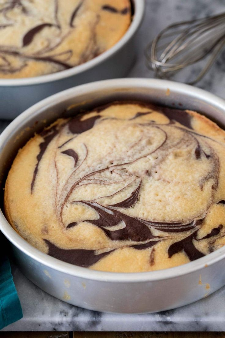 two pans filled with cake sitting on top of a counter