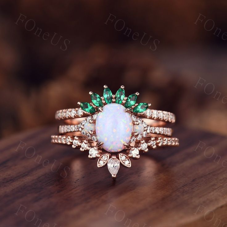 an opal and diamond ring on top of a wooden table