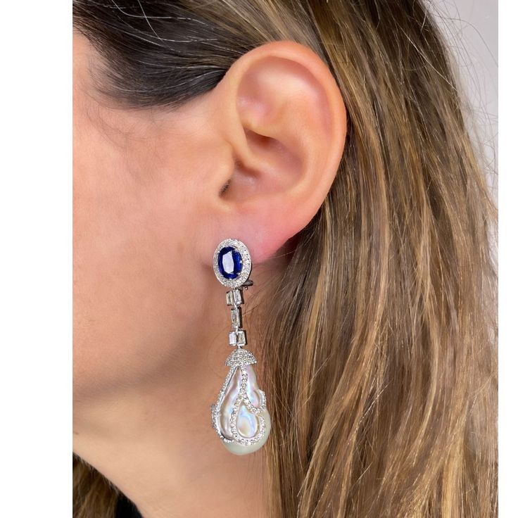 Delivery in 4-6 weeks Need it faster? Text us at (619) 247.5731 or Call us at (619) 365.4736 This pair of earrings are perfect for special occasions, this design gives the piece a feminine touch. Pearl, Kyanite & Diamonds Earrings Diamond: 1.77 ct Diamond Baguettes: 0.9 ct Pearl: 56.36 ct Kyanite: 4.65 ct Silver with Rhodium Plated weight: 8.3 grams Sapphire Earrings With Diamond Accents For Evening, Evening Earrings With Sapphire And Diamond Accents, Evening Sapphire Earrings With Diamond Accents, Formal White Gold Pear-shaped Earrings, Formal Pear-shaped White Gold Earrings, Luxury Sterling Silver Pear-shaped Earrings, Luxury Pear-shaped Sterling Silver Earrings, Luxury Sapphire Drop Earrings, White Gold Sapphire Earrings For Evening