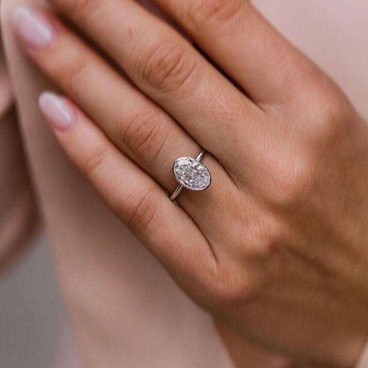 a close up of a person wearing a ring with a heart shaped diamond on it