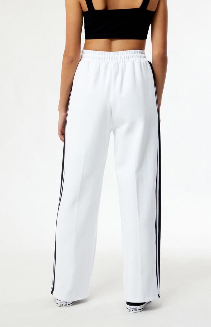 PacSun exclusive! Introducing the Coney Island Picnic x Everlast Wide Leg Track Pants, a winning combination of retro aesthetics and contemporary comfort. Crafted for both style and functionality, these track pants boast a wide-leg silhouette that nods to vintage sportswear while ensuring a modern fit. Featuring contrast side stripes and pintuck details, these pants add a touch of athletic flair to your look. With the iconic collaboration embroidery at the hip, these high-waisted pants are the perfect blend of nostalgia and streetwear flair.


	Solid color track pants
	28" inseam
	13" rise
	High-rise
	Drawstring waistband
	Side hand pockets
	Everlast x Coney embroidery
	Pintuck details
	Wide leg openings
	Contrast side stripes
	Relaxed fit
	80% cotton, 15% polyester, 5% elastane Vintage Sportswear, Youth Culture, Coney Island, Side Stripe, Pin Tucks, Drawstring Waistband, Pacsun, Modern Fit, Track Pants