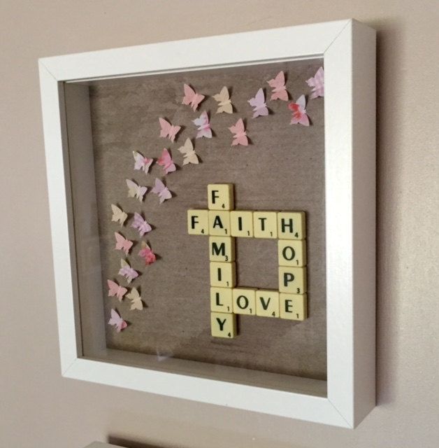 a scrabble frame with words and butterflies in the shape of letters that spell out faith