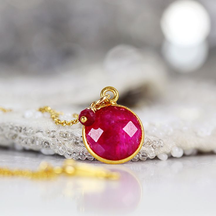 Back in stock! This striking Ruby necklace looks rich and exotic, and is perfect for adding colour to any outfit or occasion. Featuring a sparkling, round, cut and faceted ruby set in a bezel setting and paired with a dangling ruby gem. Available in various lengths. Rubies are the birthstone for July and the 40th wedding anniversary. Ruby jewelry makes a perfect romantic gift for a loved one, whether for a birthday, anniversary or Valentine's Day, as Rubies have always been associated with love Round Ruby Necklace For Party, Red Gemstone Round Necklace, Red Round Necklace For Her, Red Gemstone Crystal Necklace With Round Shape, Briolette Gemstone Beads Necklace As Gift, Briolette Gemstone Bead Necklace As A Gift, Ruby Birthstone Necklaces, Red Faceted Pendant Necklaces, Red Faceted Pendant Necklace