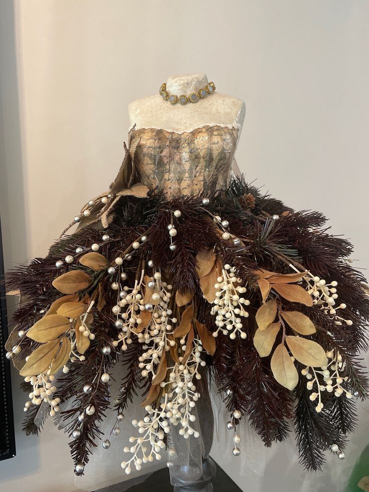 a mannequin is adorned with flowers and leaves