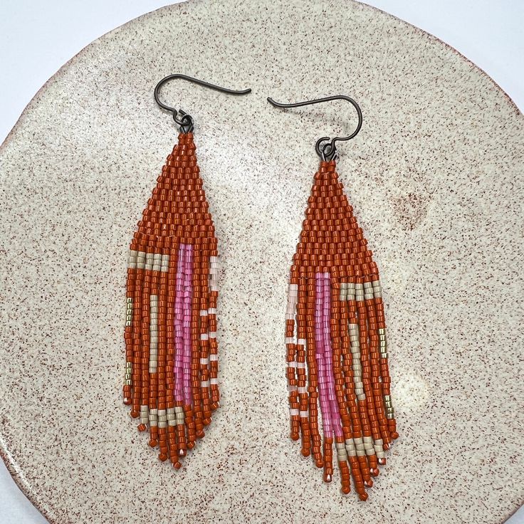 - handwoven with delica seed beads size 11/0 - width : .75 inch - drop length from the top to the last bead on the longest fringe is 3.5 inches - handmade in new york Beaded Heishi Beads Dangle Earrings, Artisan Beaded Heishi Beads Earrings, Artisan Beaded Earrings With Heishi Beads, Handmade Heishi Beads Earrings For Festivals, Artisan Dangle Earrings With Heishi Beads, Orange Handwoven Dangle Beaded Earrings, Artisan Handwoven Teardrop Earrings, Bohemian Beaded Earrings With Heishi Beads, Bohemian Heishi Beaded Earrings With Ear Wire